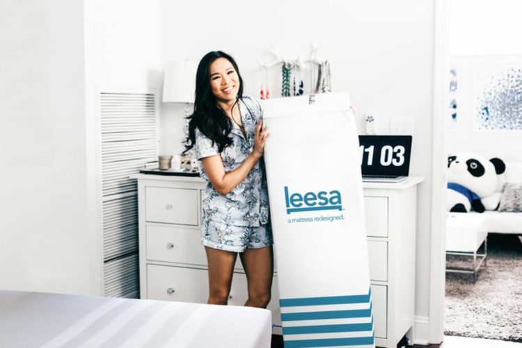 girl-with-a-box-of-leesa-mattress-750x501